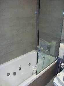 Sector bañera con hidromasaje y paredes en porcelánico.